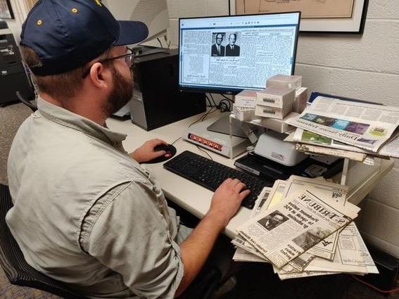 尼克·加德纳, interim program coordinator for the 网上赌博网站十大排行 library, demonstrates how easily accessible some local newspapers are now that these have been digitized. 